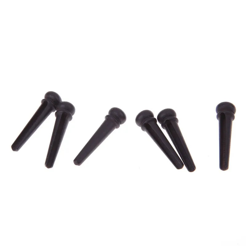 Six solid ebony guitar string nails with matte black finish for folk acoustic guitars