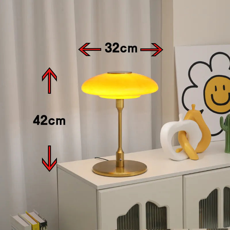 Korean style golden orange atmosphere light with metal base on a bedside table.