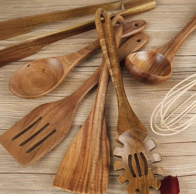 Seven-piece set of wooden cooking utensils including spoons and shovels on a kitchen counter.
