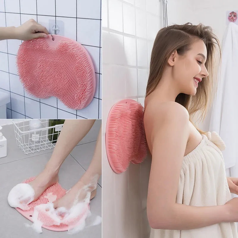 Orange silicone bath massage brush with suction cups on a bathroom tile floor.