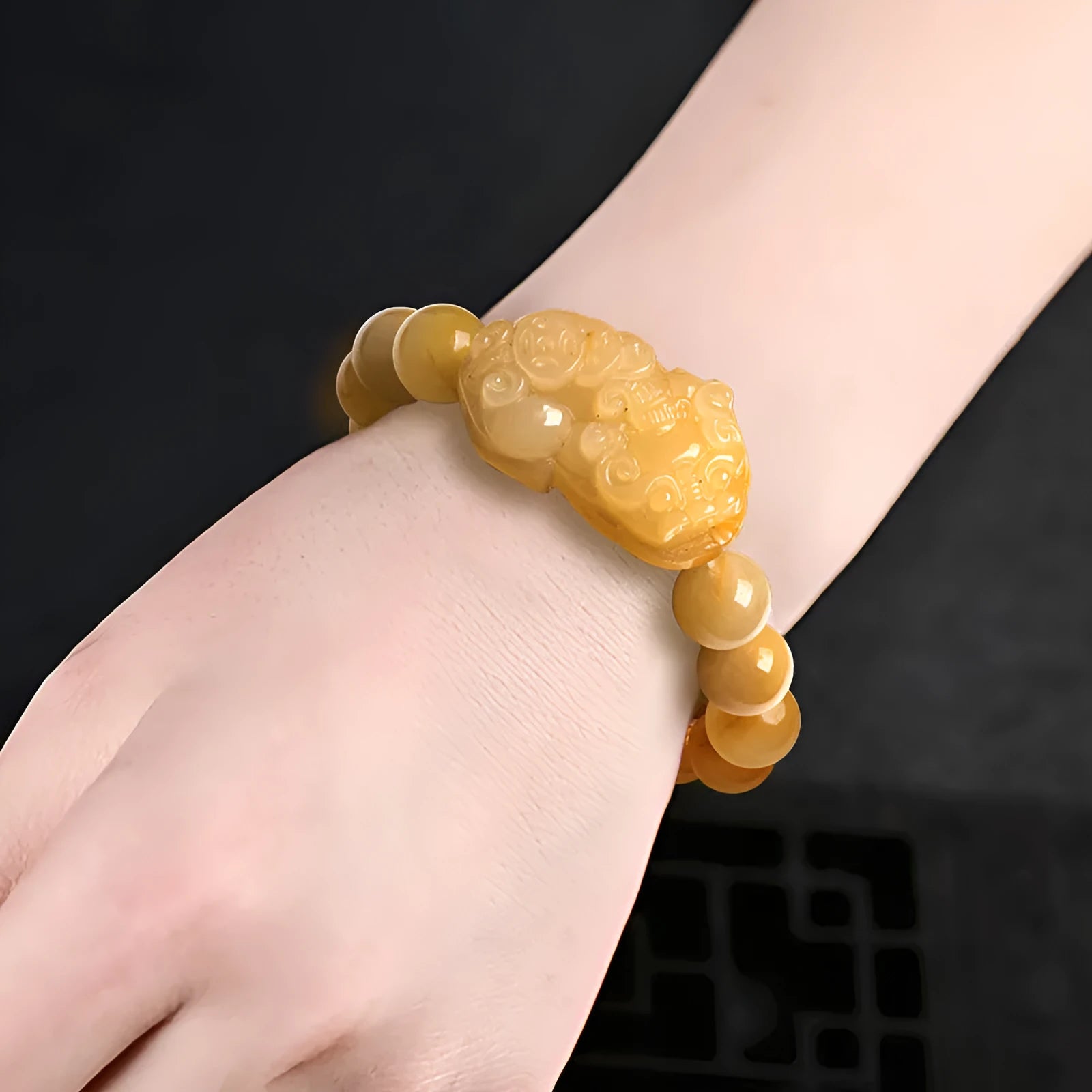 Carved Jinsi jade money bracelet showing golden thread texture and bead details
