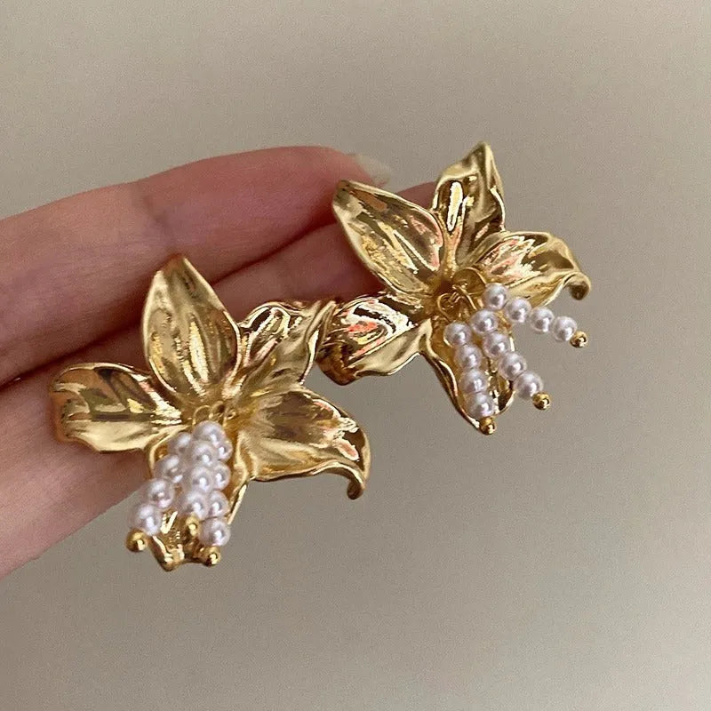 A pair of gold H1795 coloured flower-shaped drop earrings with a pearl centre.