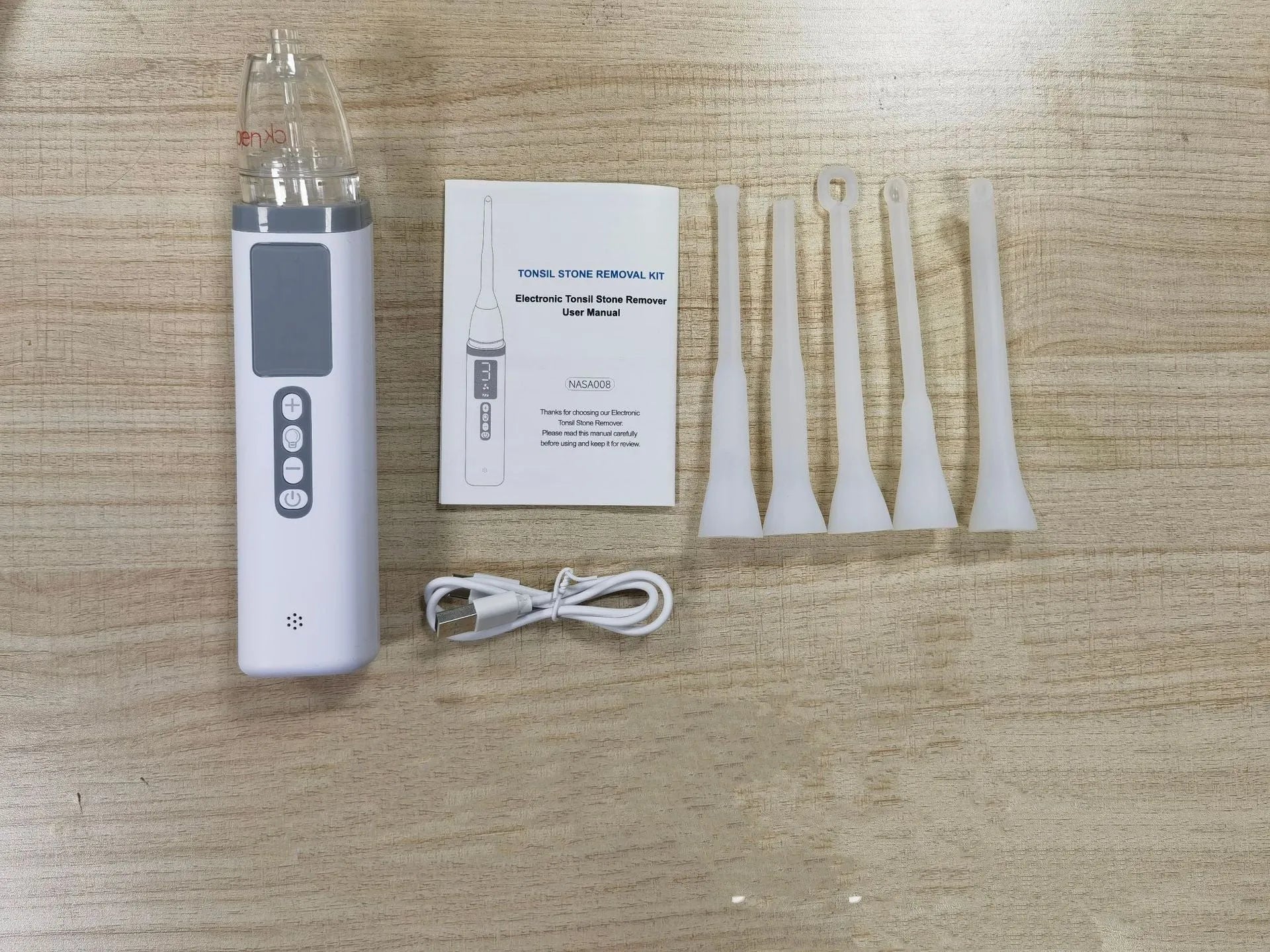 Milky white manual tonsil stone extractor oral cleaning tool set on a white background