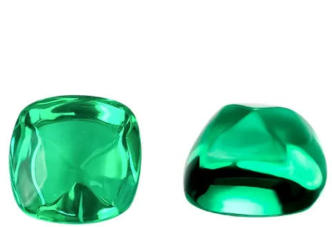 A loose cultivated emerald gemstone in Columbia green treasure colour on a white background.