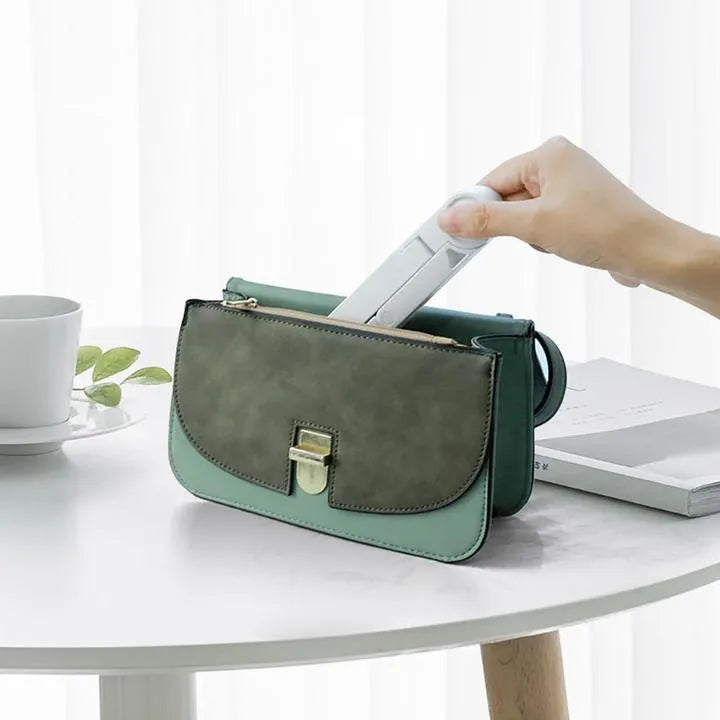 Black foldable tablet holder open on a desk supporting a tablet in landscape mode.