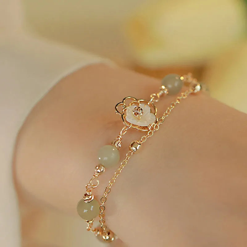 Yellow gold butterfly bracelet on copper base with geometric shape.