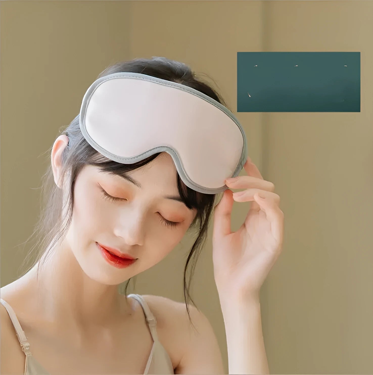Portable green eye SPA massage goggles with suede shell on a grey background.