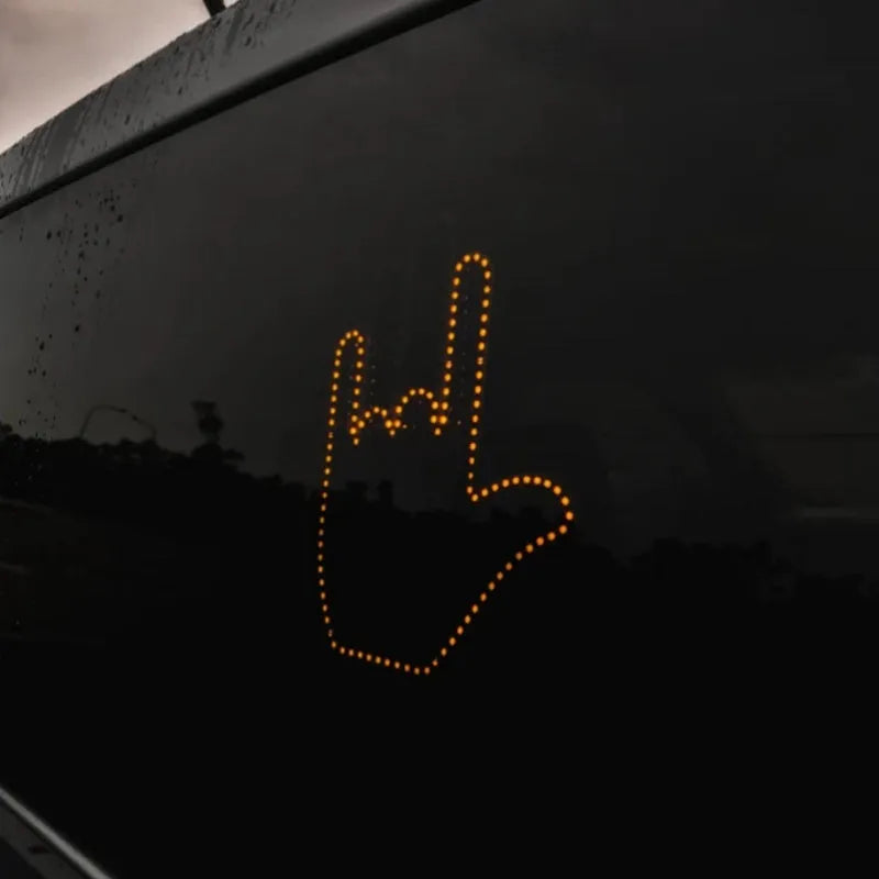 Black plastic LED gesture light for cars showing middle finger symbol with remote control
