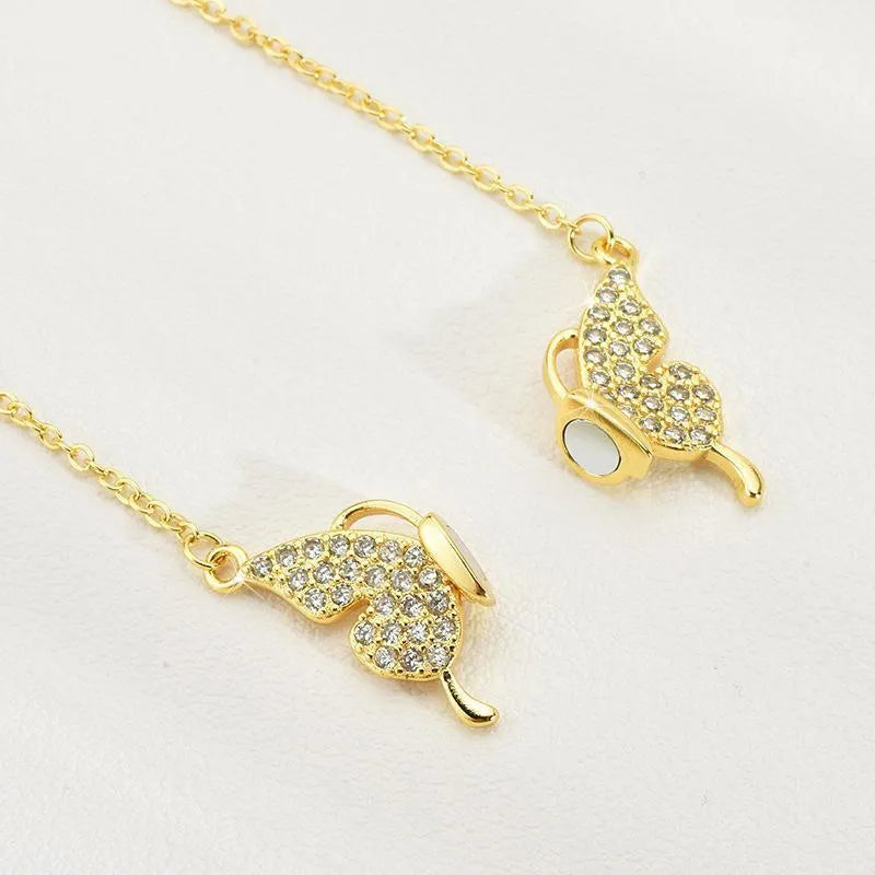 Gold titanium steel necklace with butterfly pendant on twisted chain and magnetic clasp.