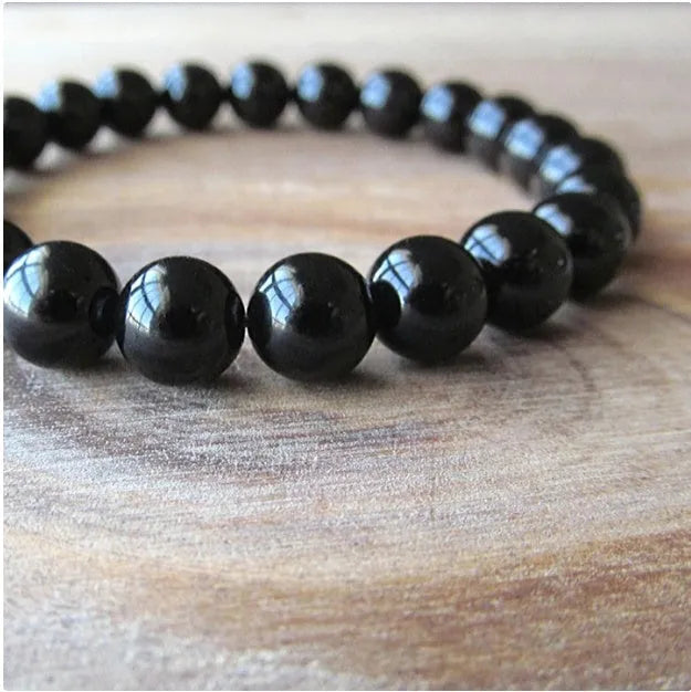 Geometric black agate bracelet with 8mm beads on a black elastic cord for women.