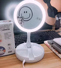 White foldable LED vanity mirror with storage tray and USB cable.