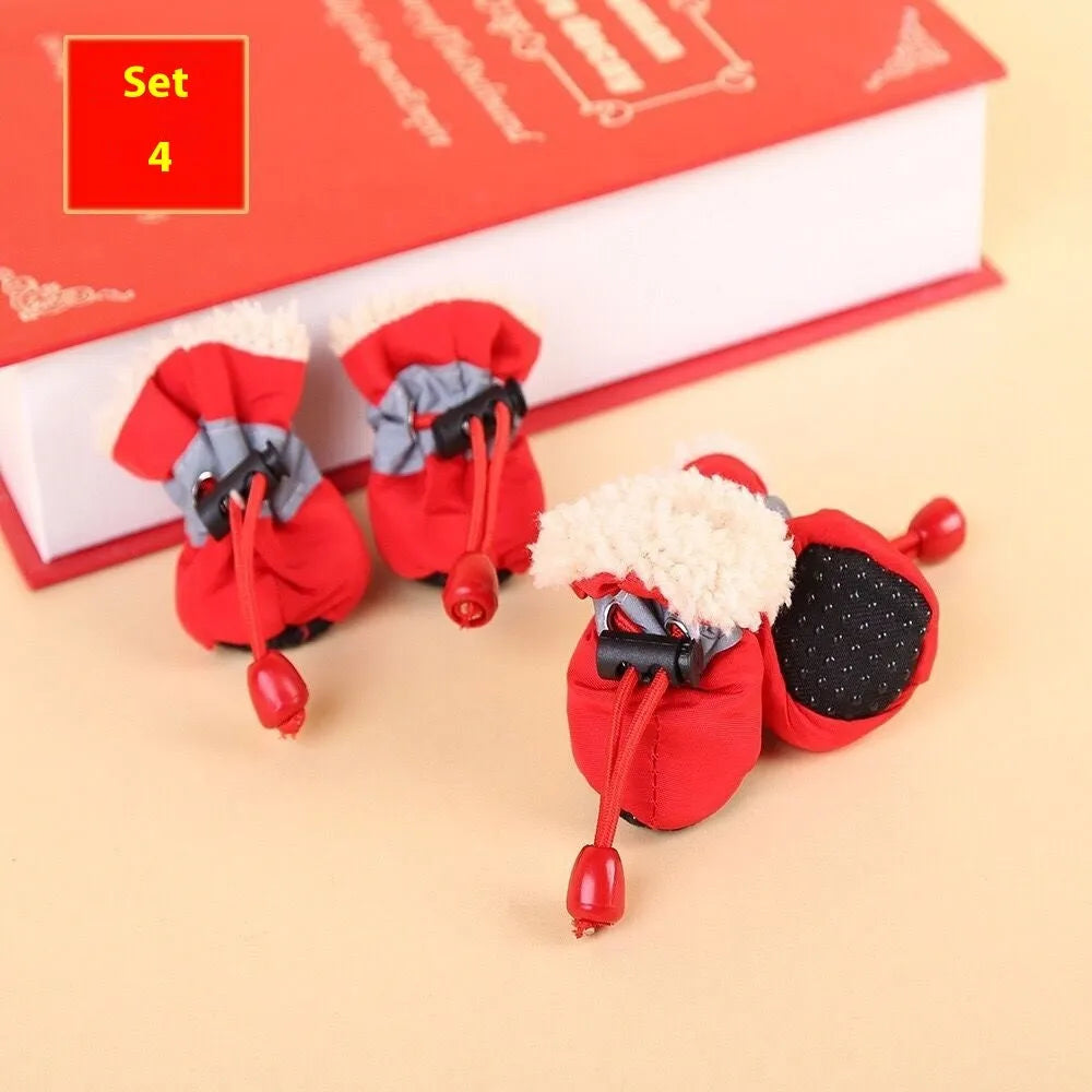 Set of four cloth dog shoes with soft soles in assorted colours on a neutral background