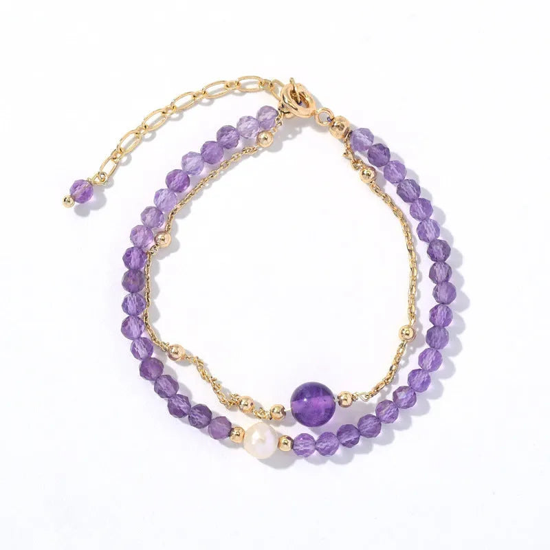 Close-up of a Chinese style women's bracelet with diamond-shaped amethyst crystal beads and an electroplated finish.