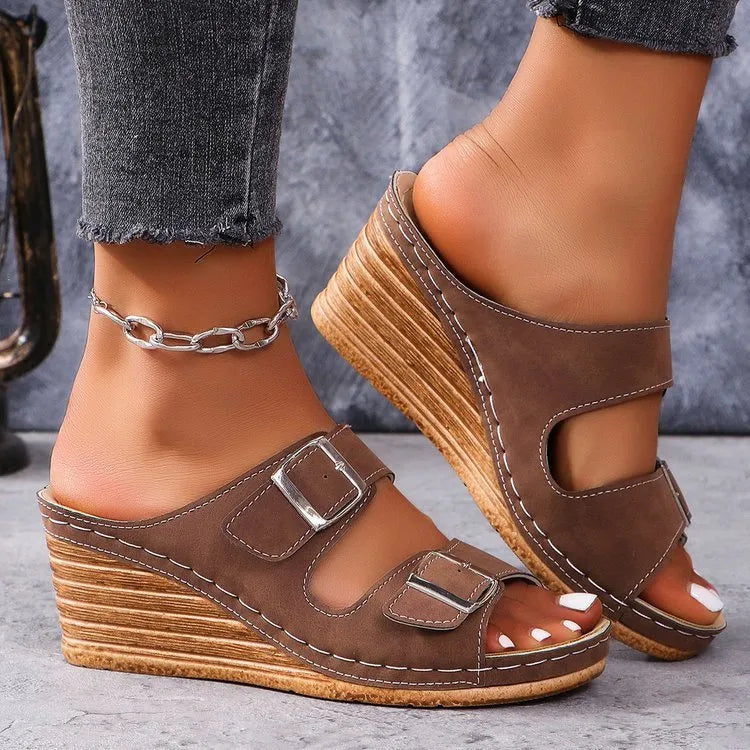 Women's creamy-white wedge beach slippers with a decorative belt buckle on the strap.
