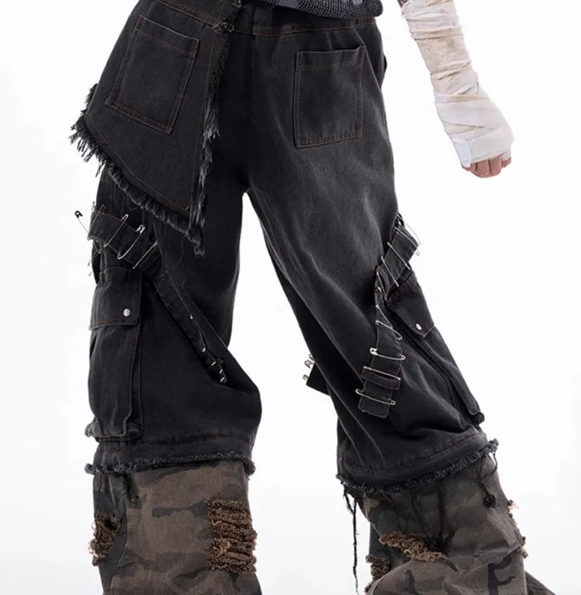 Men's grey camouflage pattern jeans with spliced panels and decorative pin details.