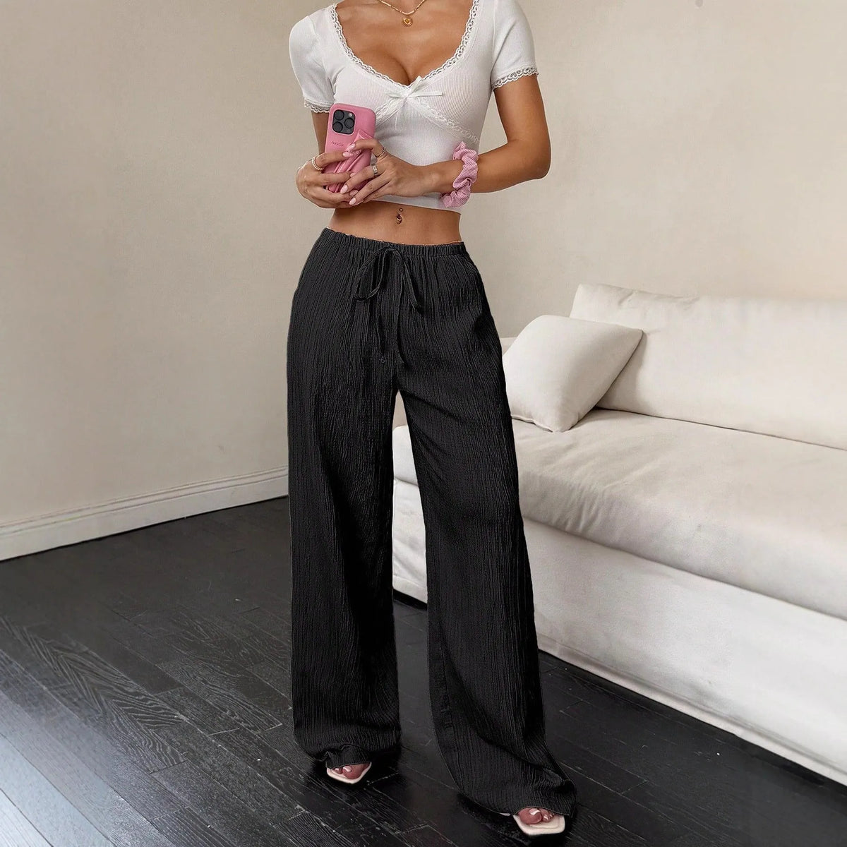 Women's black wide-leg trousers with lace-up waist trimming detail on mid-waist