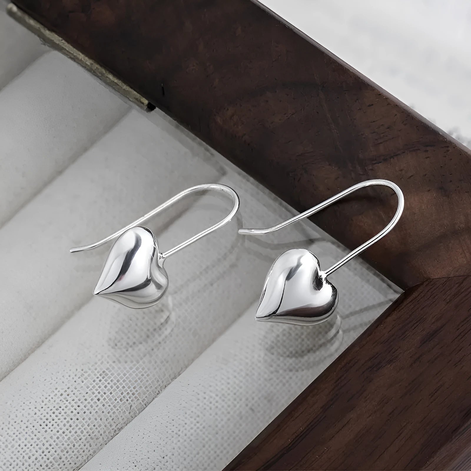 Silver Korean-style three-dimensional heart earrings with glossy finish and ear hook fastening