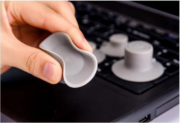 Four grey durable plastic laptop cooling pads in two sizes on a flat surface