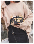 Women's hard-sided black PU shoulder bag with single strap and flap closure