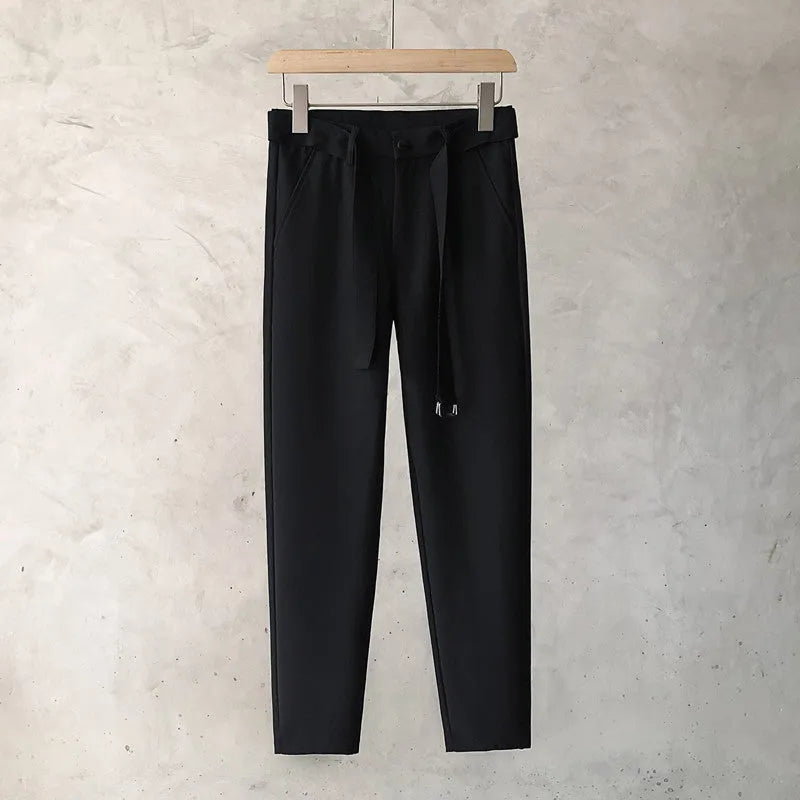 Boys slim straight-leg wool trousers in tapered cut, shown in black, on a hanger.