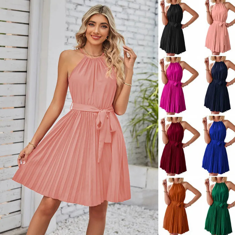 Woman wearing a black halter neck chiffon sundress with a pleated skirt and an adjustable waist tie.