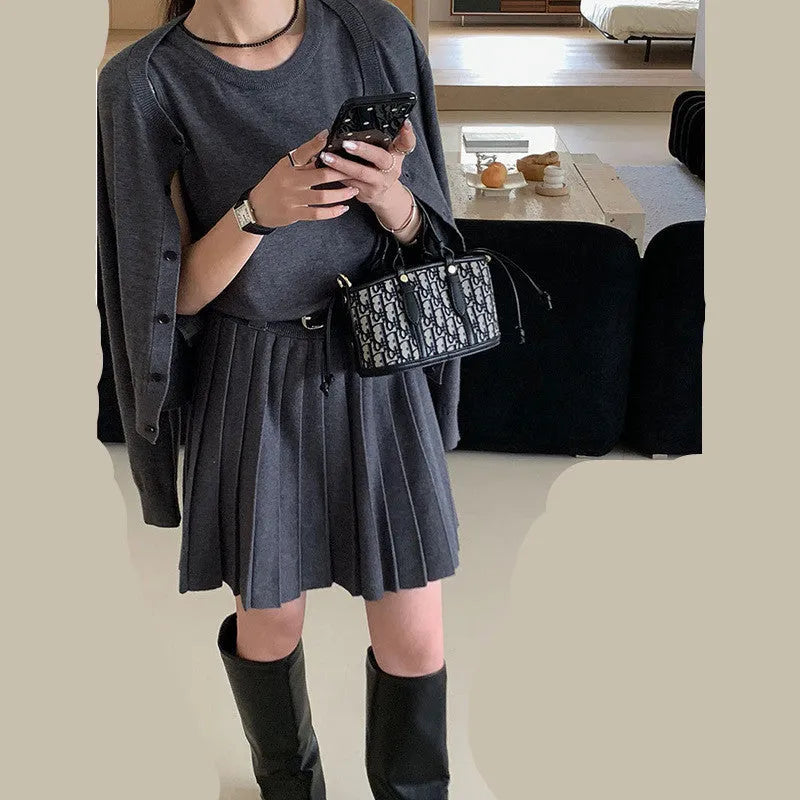 Women's black art retro knitted vest skirt and long sleeve cardigan two-piece set with belt.