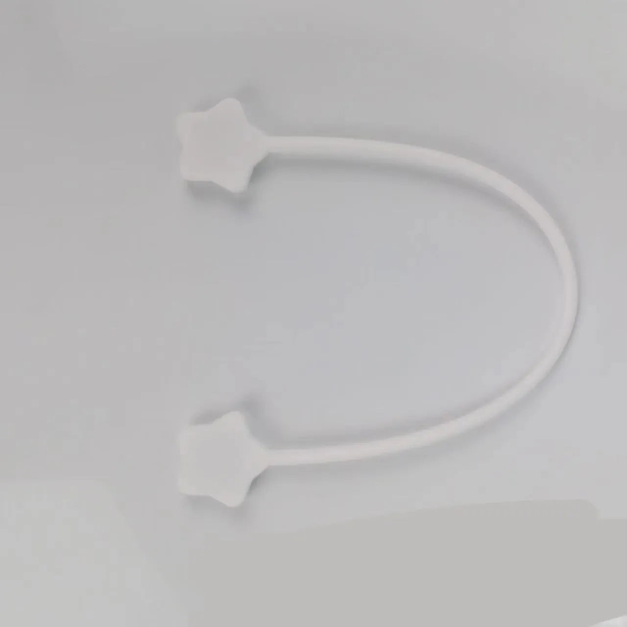 Small purple silicone wire winder clip with magnet for organising headphone and phone cables.