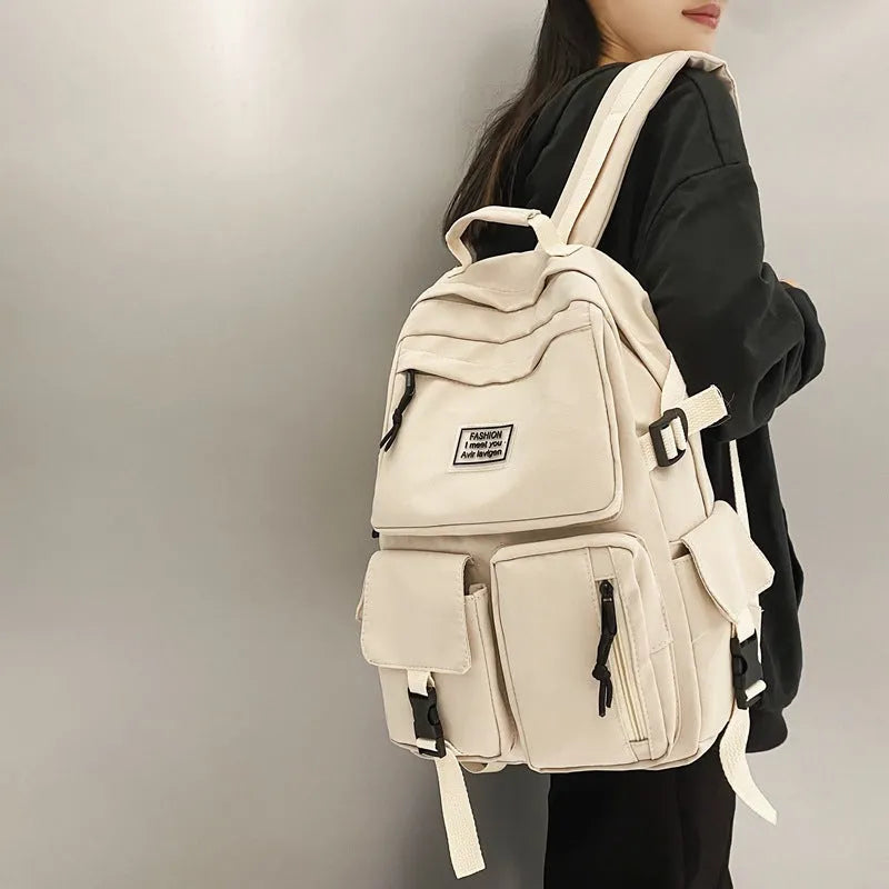 Black and white nylon student backpack with laptop compartment, showing three-dimensional pocket.
