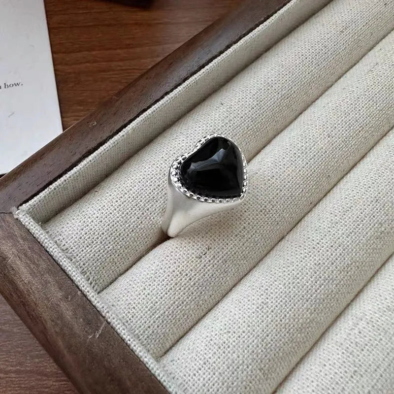 Adjustable opening sterling silver ring with black agate heart stone design on finger