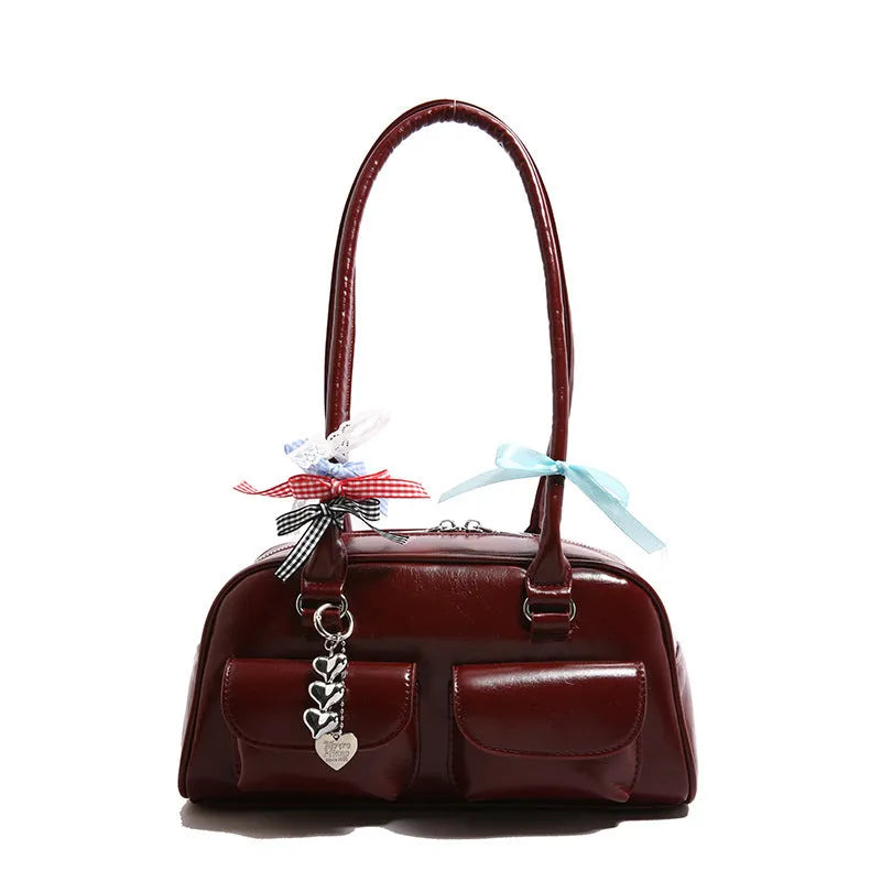 Brown PU leather women's pillow flap bag with double straps and a decorative ribbon pendant.