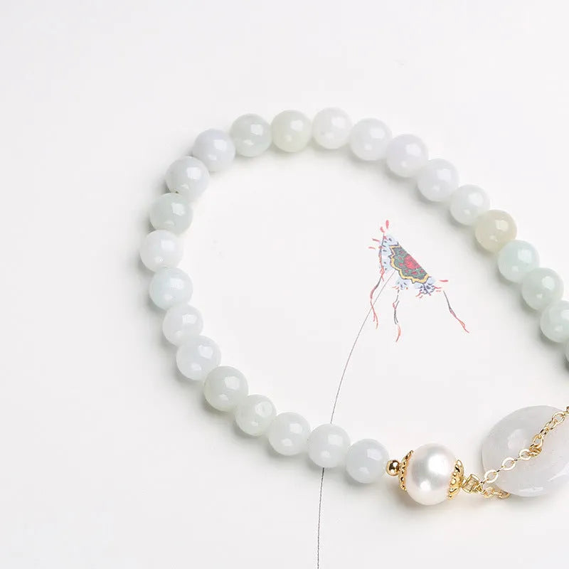 Jade green pearl bracelet with geometric pendant and peace buckle clasp on wrist