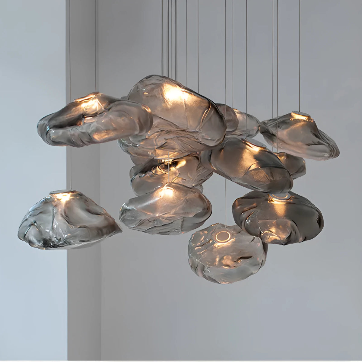 Modern glass decorative chandelier light fixture in amber, clear or smoke grey colour.