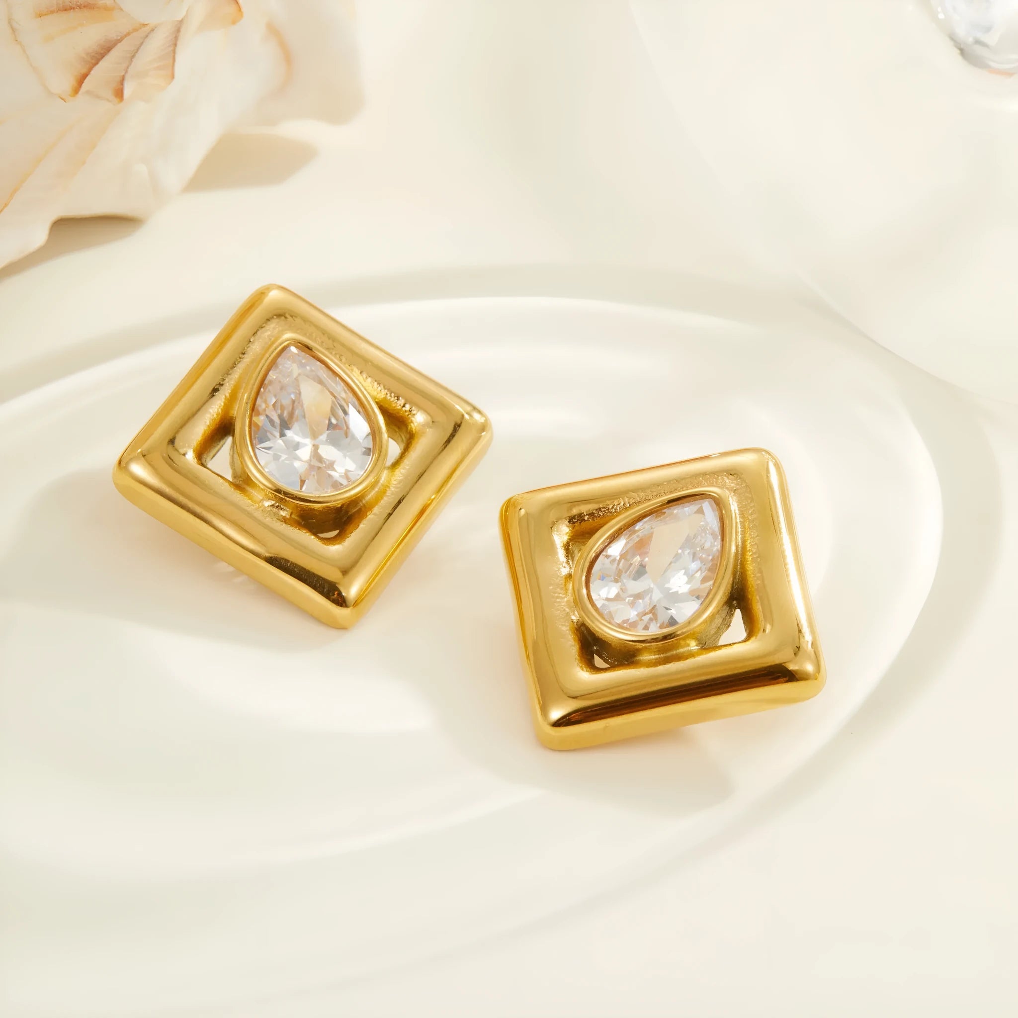 Gold-coloured geometry stud earrings with inlaid water drop zircon stones on a stainless steel base.