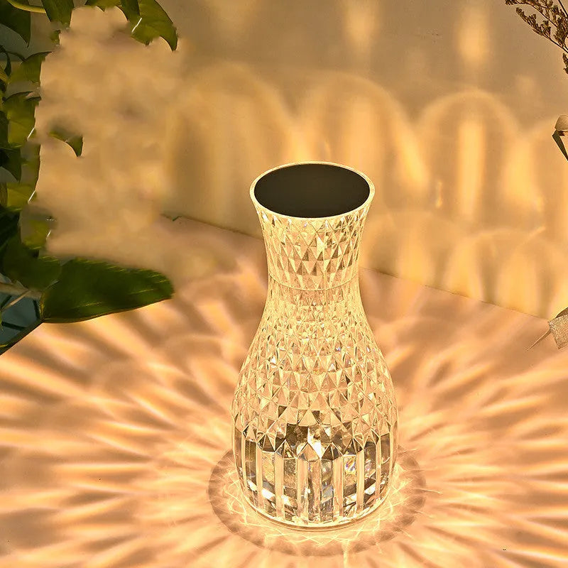 Vase-shaped crystal table lamp with LED lights and remote control on wooden bedside table