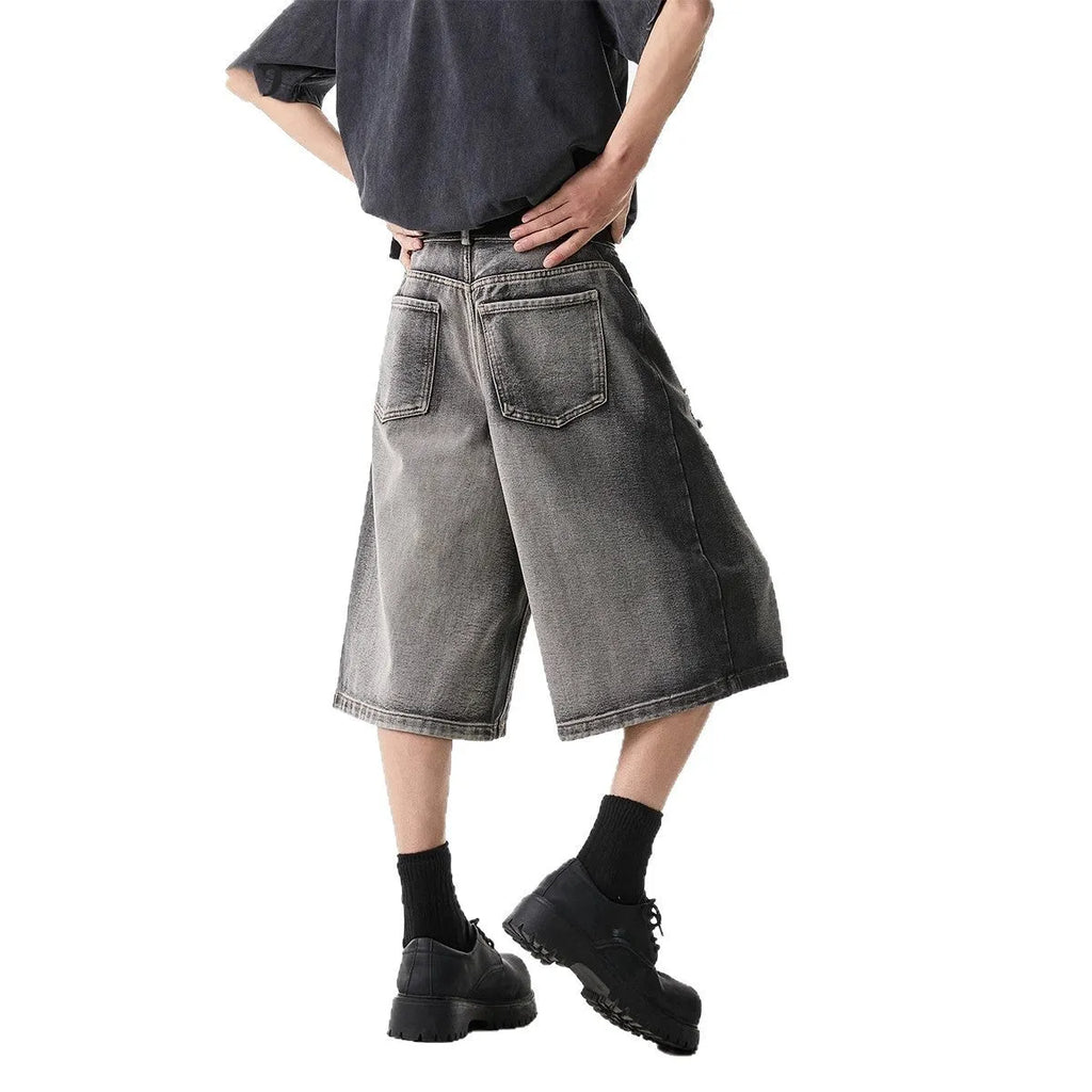 Grey women's denim shorts with distressed hole details and a loose, cropped fit