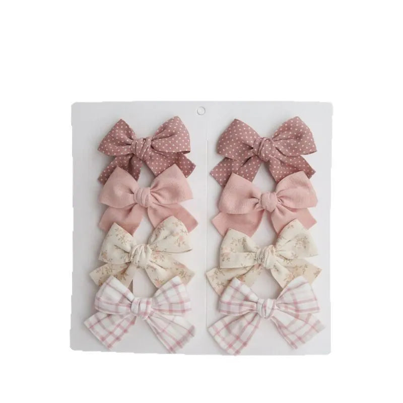 Children's dovetail bow hairclips in eight colour patterns including grid dots and floral designs