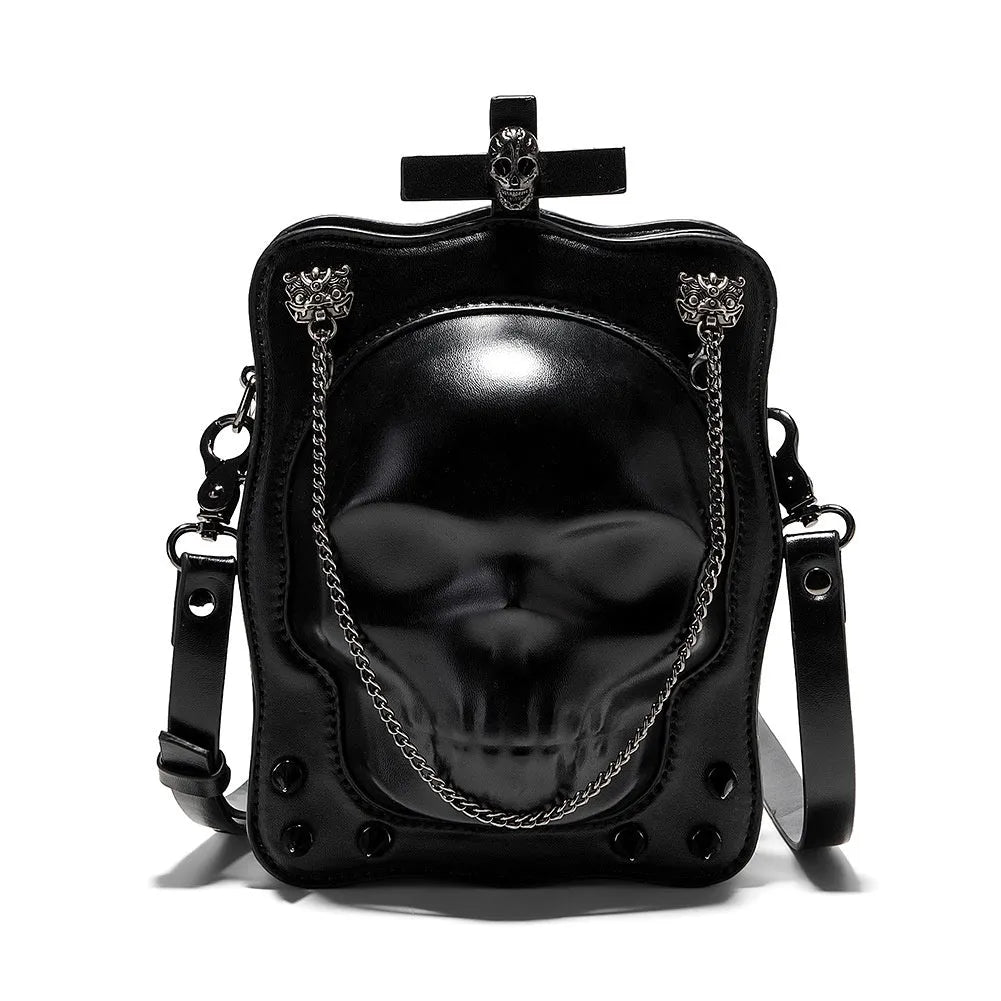 Black mini square crossbody bag with embossed skull design, metal chain strap, rivets, and contrast stitching.