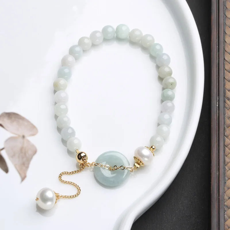 Jade green pearl bracelet with geometric pendant and peace buckle clasp on wrist