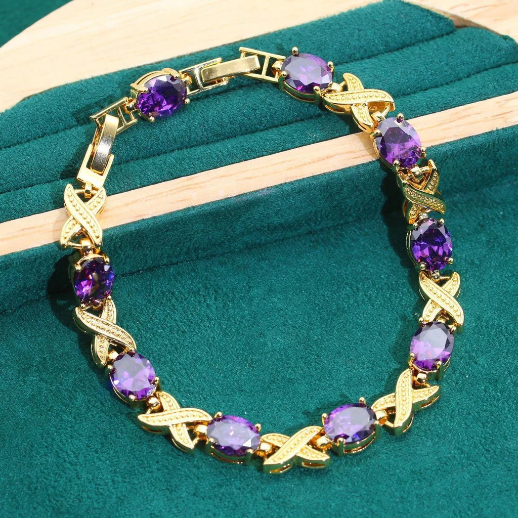 Gold plated women's jewellery set with necklace, earrings, ring, and bracelet featuring coloured zircon stones.