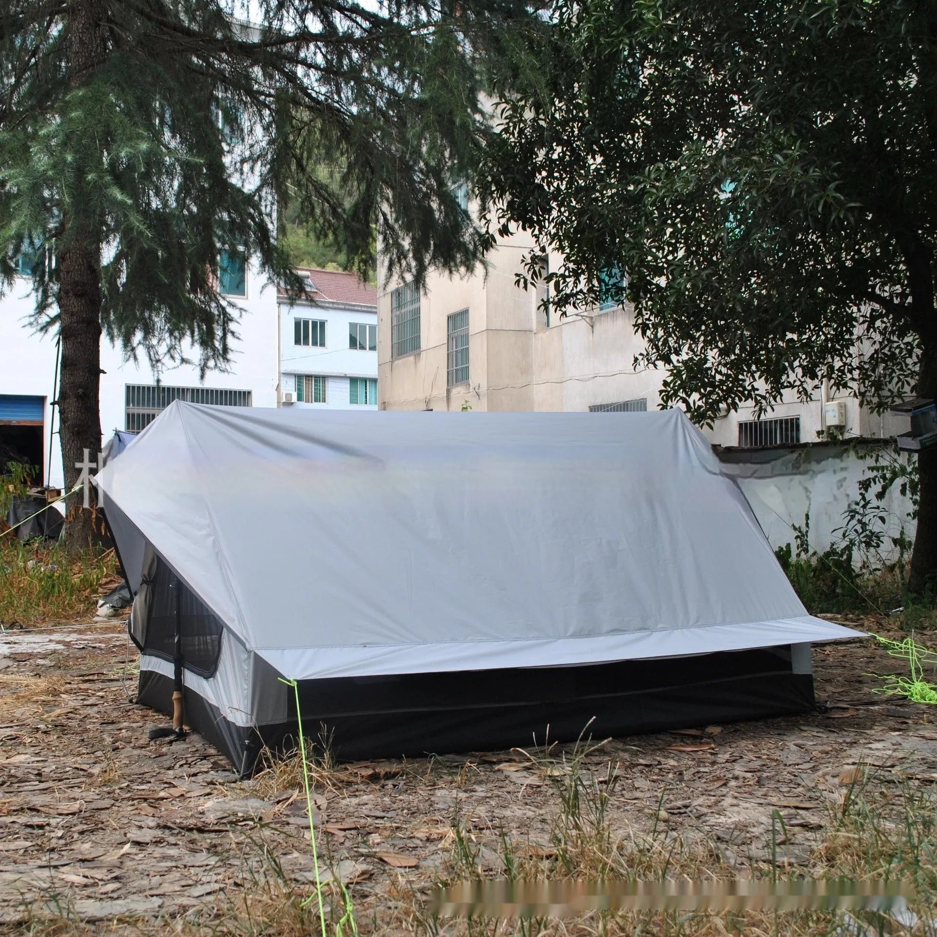 Brown and white pole-free A-line cabin tent set up with hiking canes, showing spacious interior