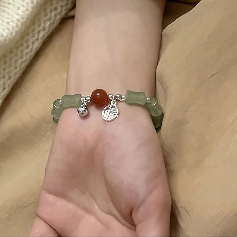 Chinese style handmade glass bead bracelet with bamboo joint elements on a white background.