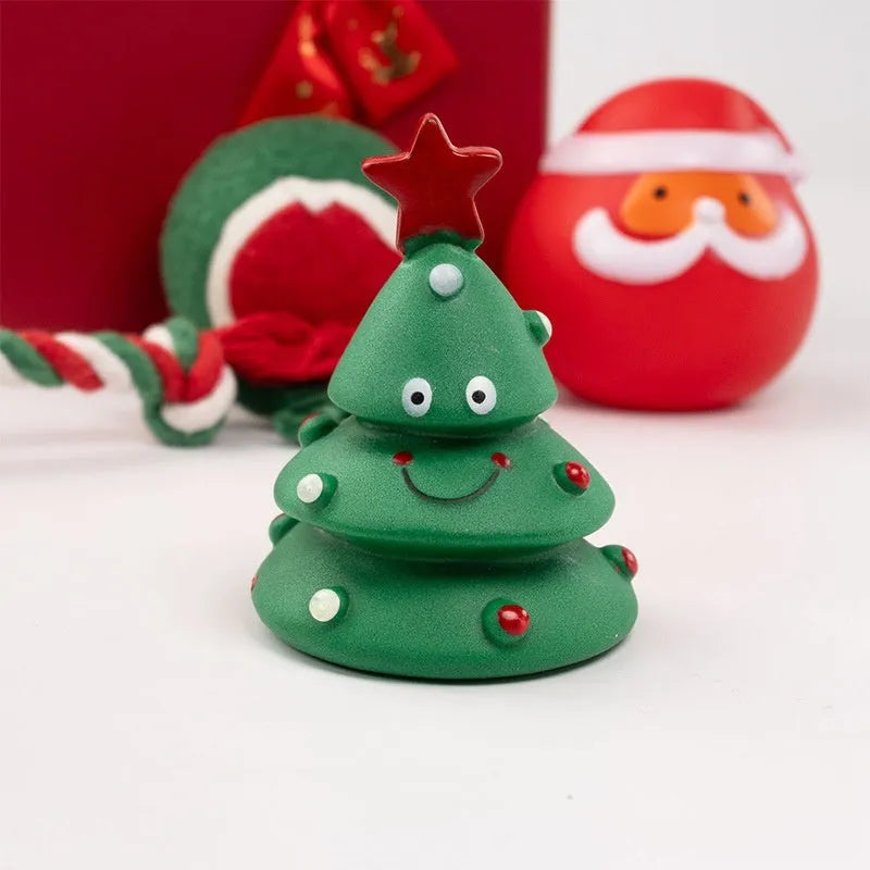 Christmas-themed vinyl dog toys including bite ropes, tennis balls, Santa heads, and deer figures in gift packaging