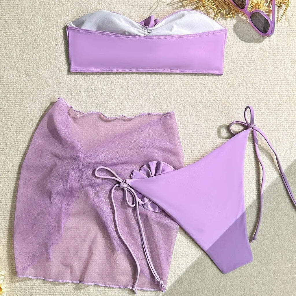 Pink women's swimsuit set with tied floral top, high-waisted bottoms, and matching skirt.