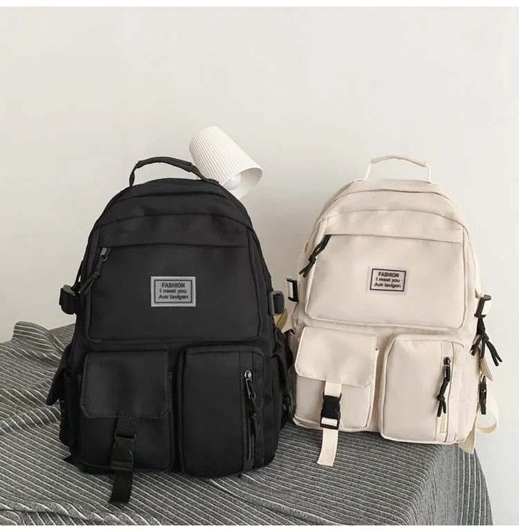 Black and white nylon student backpack with laptop compartment, showing three-dimensional pocket.
