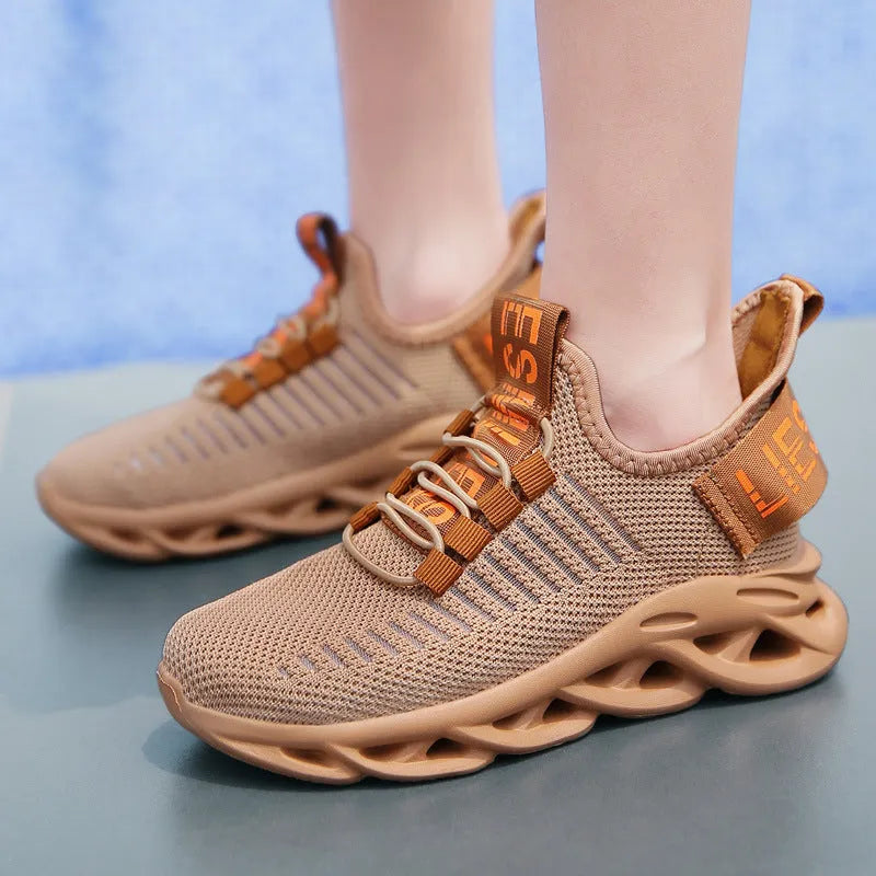 Children's fabric sneakers with Velcro strap in black, khaki, and white colours on a neutral background.