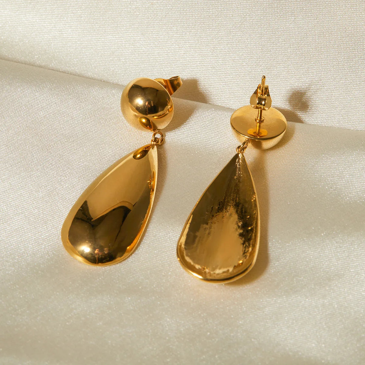 Gold-coloured stainless steel earrings with hemisphere and water drop pendant design