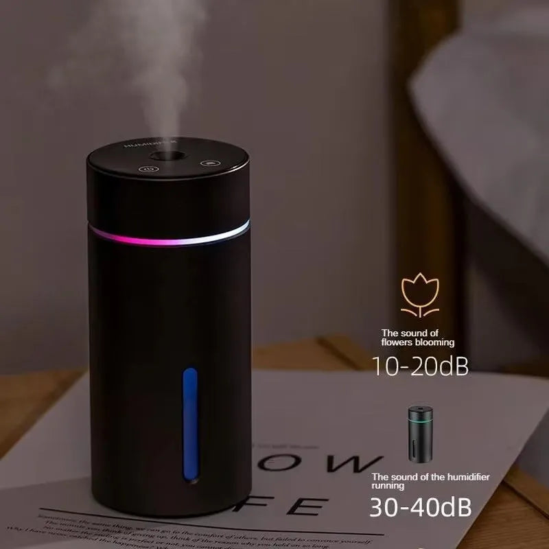 Compact aluminium car humidifier and essential oil diffuser with night light on a desk.