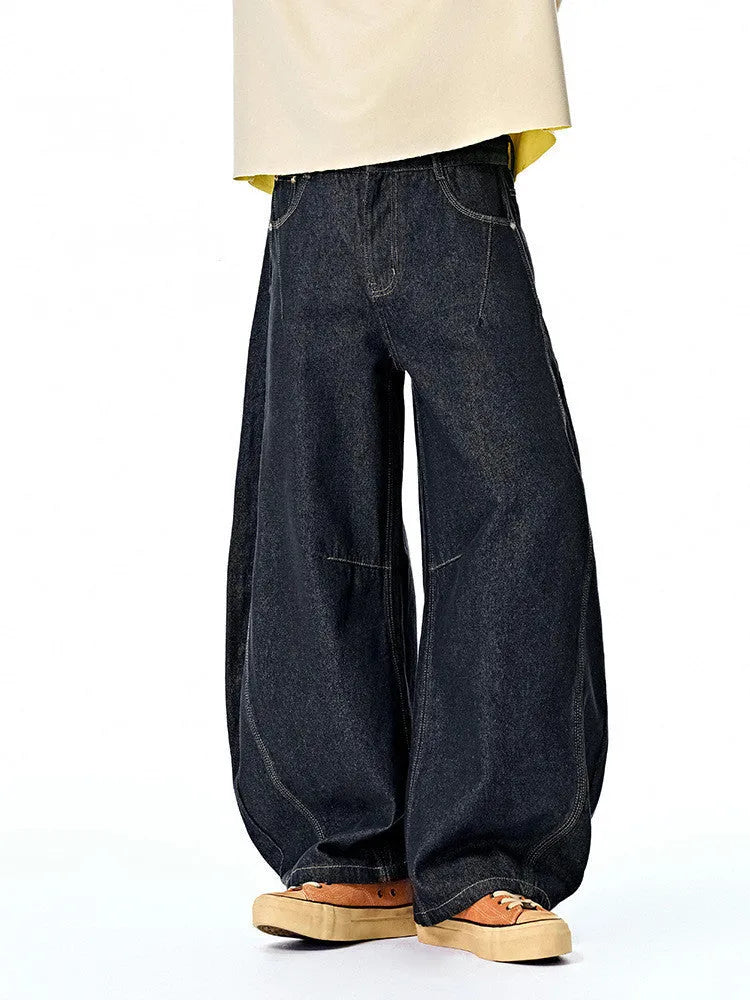 Men's wide leg denim trousers in original cow colour, showing mid waist and loose leg fit.