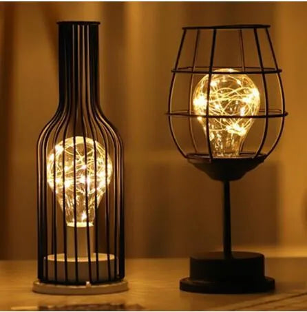 Minimalist wrought iron hollow table lamp in red wine glass style with warm white glow.