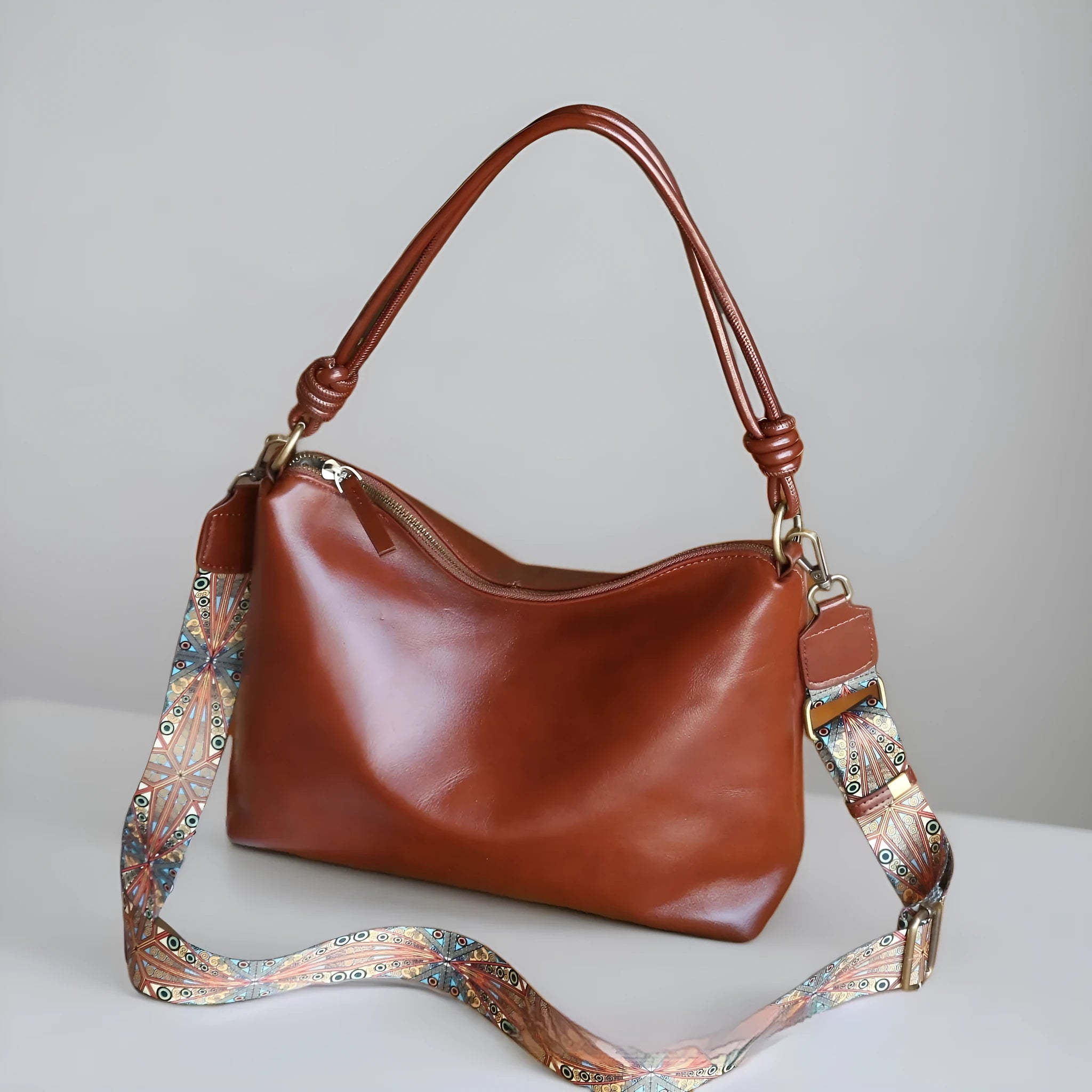 Genuine leather creative large capacity hand and shoulder commuter bag in caramel colour with pillow shape and patchwork details